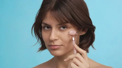 Beautiful girl using jade roller for facial massage. Facial treatment Video stock 233021536