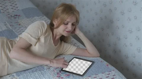 Beautiful girl using tablet pc with Isolated screen lying on bed at home  Stock Footage 63650732