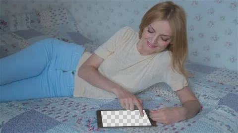 Beautiful girl using tablet pc with Isolated screen lying on bed at home  Stock Footage 63652244
