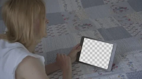 Beautiful girl using tablet pc with Isolated screen lying on bed at home  Stock Footage 63652596