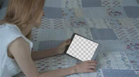 Beautiful girl using tablet pc with Isolated screen lying on bed at home  Stock Footage 63653565