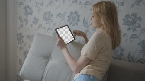 Beautiful girl using tablet pc with Isolated screen sitting on sofa at home  Stock Footage 63654212