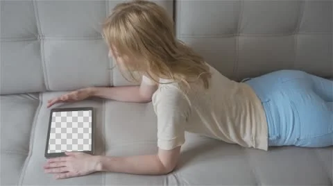 Beautiful girl using tablet pc with Isolated screen laying on sofa at home Stock Footage 64369494