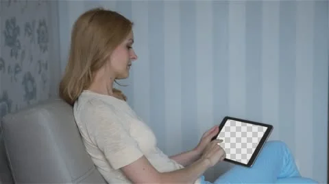 Beautiful girl using tablet pc with Isolated screen sitting on sofa at home Stock Footage 64369673