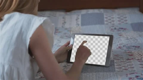 Beautiful girl using tablet pc with Isolated screen lying on bed at home Stock Footage 64369928