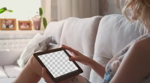 Beautiful girl using tablet pc with Isolated screen laying on sofa at home 5 Stock Footage 64989322