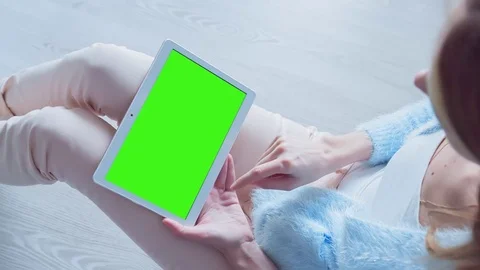 Beautiful Girl Using Tablet PC with Pre Keyed Green Screen Sitting on the Floor Stock Footage 73157113