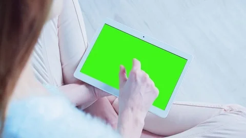 Beautiful Girl Using Tablet PC with Pre Keyed Green Screen Sitting on the Floor Stock Footage 73157457