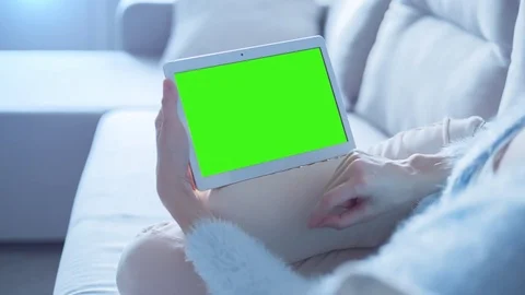 Beautiful Girl Using Tablet PC with Green Screen Laying on Sofa at Home 4 Stock Footage 73213493