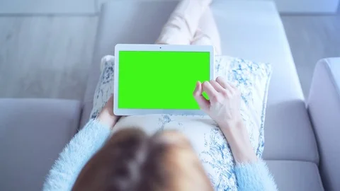 Beautiful Girl Using Tablet PC with Green Screen Laying on Sofa at Home 7 Stock Footage 73228942