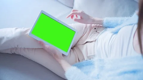 Beautiful Girl Using Tablet PC with Green Screen Laying on Sofa at Home 11 Stock Footage 73270490