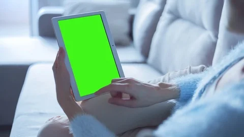 Beautiful Girl Using Tablet PC with Green Screen Laying on Sofa at Home 8 Stock Footage 73274464