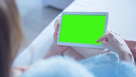 Beautiful Girl Using Tablet PC with Green Screen Laying on Sofa at Home 15 Stock Footage 73306111