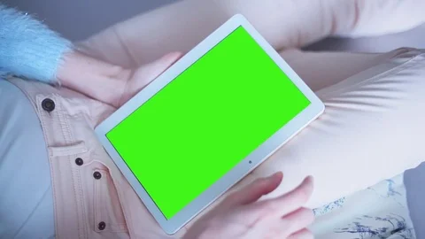 Beautiful Girl Using Tablet PC with Green Screen Laying on Sofa at Home 19 Video stock 73351633