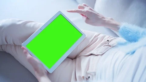 Beautiful Girl Using Tablet PC with Green Screen Laying on Sofa at Home 12 Video stock 73352253