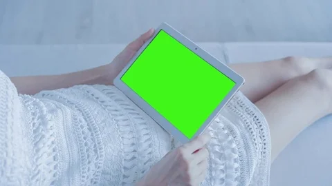 Beautiful Girl Using Tablet PC with Green Screen Laying on Sofa at Home 24 Video stock 73800321