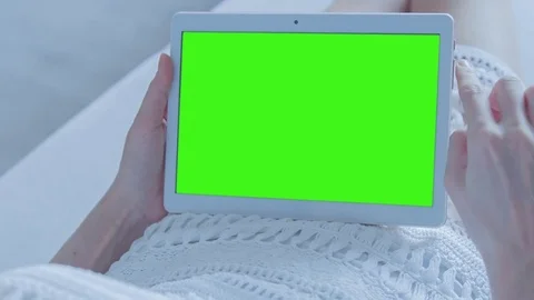 Beautiful Girl Using Tablet PC with Green Screen Laying on Sofa at Home Stock Footage 74143741