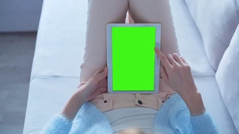 Beautiful Girl Using Tablet PC with Green Screen Laying on Sofa at Home Stock Footage 74143794