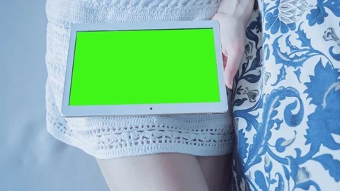Beautiful girl using tablet pc with Pre-Keyed Green Screen sitting on sofa Stock Footage 74170472