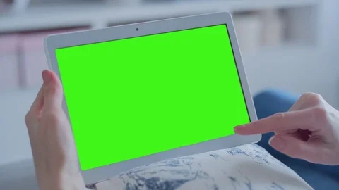 Beautiful girl using tablet pc with Pre-Keyed Green Screen sitting on sofa Video stock 75026294
