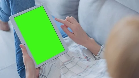 Beautiful Girl Using Tablet PC with Green Screen Laying on Sofa at Home 55 Video stock 75251927