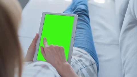 Beautiful Girl Using Tablet PC with Green Screen Laying on Sofa at Home 62 Stock Footage 75358194