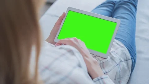 Beautiful Girl Using Tablet PC with Green Screen Laying on Sofa at Home 61 Video stock 75358255