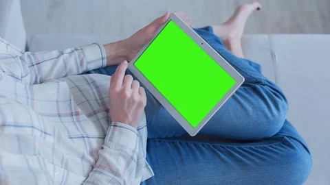 Beautiful Girl Using Tablet PC with Green Screen Laying on Sofa at Home 65 Stock Footage 75396919