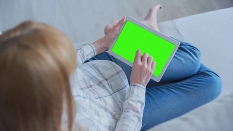Beautiful Girl Using Tablet PC with Green Screen Laying on Sofa at Home 66 Stock Footage 75398696
