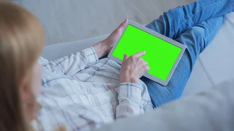 Beautiful Girl Using Tablet PC with Green Screen Laying on Sofa at Home 67 Stock Footage 75399040