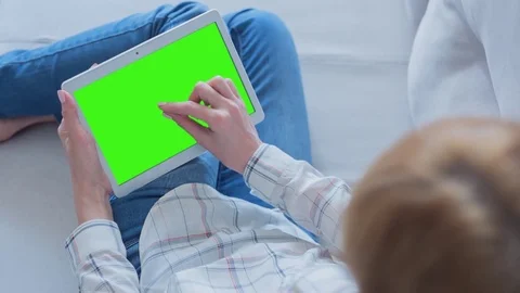 Beautiful Girl Using Tablet PC with Green Screen Laying on Sofa at Home 64 Stock Footage 75433162