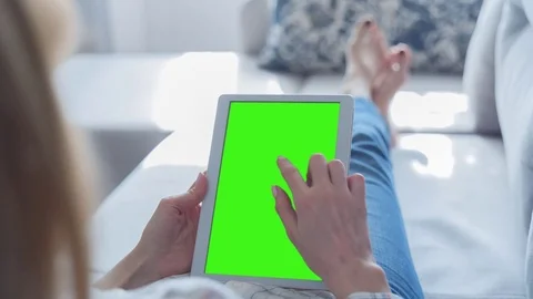Beautiful Girl Using Tablet PC with Green Screen Laying on Sofa at Home 73 Stock Footage 75435764