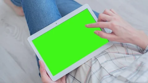 Beautiful Girl Using Tablet PC with Pre-Keyed Green Screen Sitting on the Floor Video stock 75453924