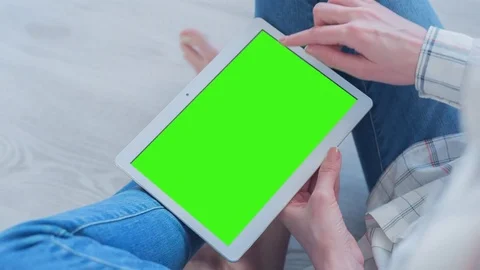 Beautiful Girl Using Tablet PC with Pre-Keyed Green Screen Sitting on the Floor Video stock 75478904