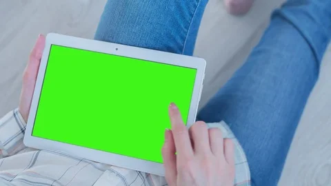Beautiful Girl Using Tablet PC with Pre-Keyed Green Screen Sitting on the Floor Video stock 75540349