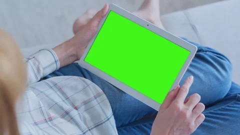 Beautiful Girl Using Tablet PC with Green Screen Laying on Sofa at Home Stock Footage 75556610