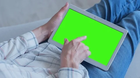 Beautiful Girl Using Tablet PC with Green Screen Laying on Sofa at Home Video stock 75557301