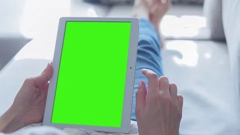 Beautiful Girl Using Tablet PC with Green Screen Laying on Sofa at Home Video stock 75559272