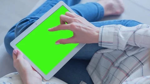 Beautiful Girl Using Tablet PC with Green Screen Laying on Sofa at Home Video stock 75559549