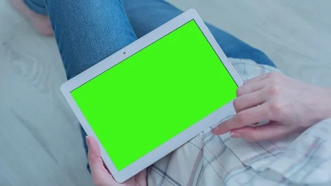 Beautiful Girl Using Tablet PC with Pre-Keyed Green Screen Sitting on the Floor Video stock 75568983