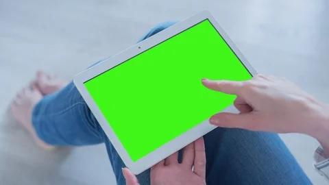 Beautiful Girl Using Tablet PC with Pre-Keyed Green Screen Sitting on the Floor Video stock 75576468
