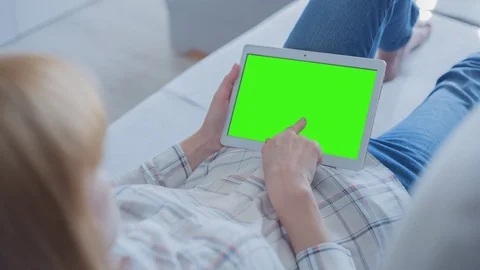 Beautiful Girl Using Tablet PC with Green Screen Laying on Sofa at Home 74 Stock Footage 75623340