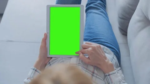 Beautiful Girl Using Tablet PC with Green Screen Laying on Sofa at Home 75 Stock Footage 75624054