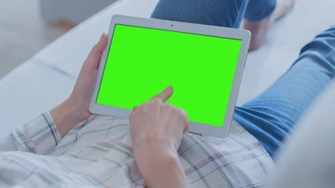 Beautiful Girl Using Tablet PC with Green Screen Laying on Sofa at Home Stock Footage 75820590