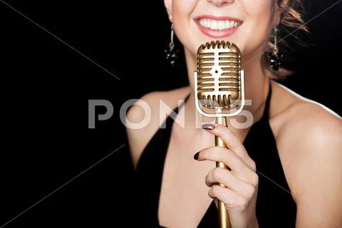 Beautiful girl vocalist with smile holding golden vintage microphone Stock Photos