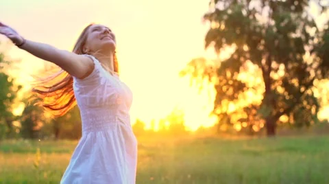 Beautiful girl in white dress enjoying nature on a spring field. Stock Footage 59089331