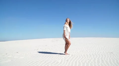 Beautiful girl in a white dress standing in the desert Stock Footage