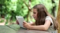 Beautiful girl with white tablet computer sits at the table HD Footage