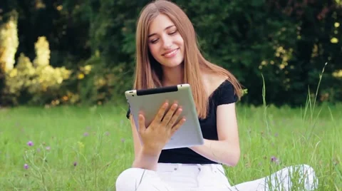 Beautiful Girl Working on a Tablet While Sitting in the park . Slow Motion 스톡 동영상 53252890
