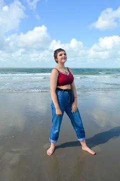 Beautiful  gitl  stands on the beach in front of the sea Stock Photos